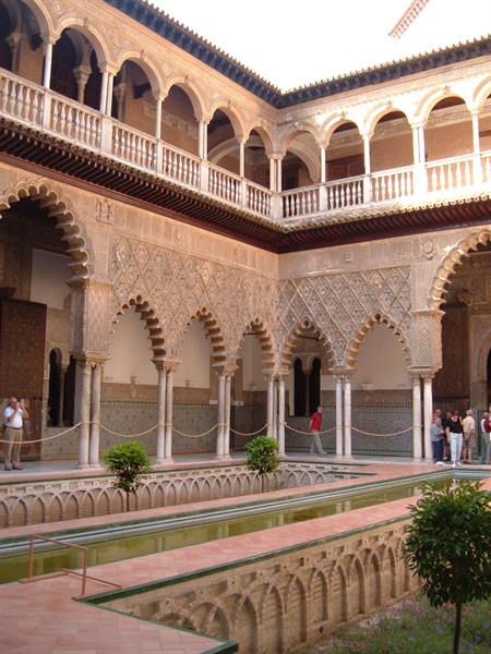 Courtyard with reflecting pool and ornate arches in Seville's Alcázar