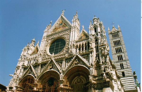 Gothic facade of Siena Cathedral with rose window and striped bell tower