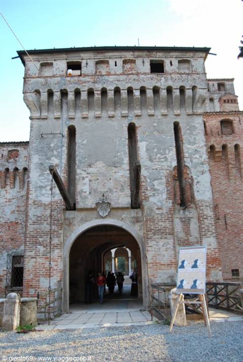 Soncino Castle, brick gatehouse with drawbridge and visitors under the arch