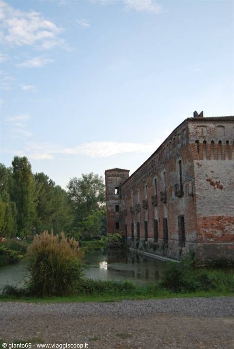 Old brick castle with water-filled moat and corner tower