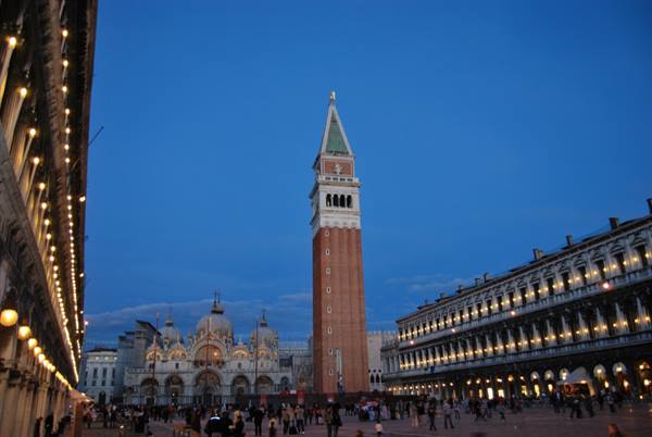 St Mark's Campanile in Venice at dusk, with the illuminated basilica