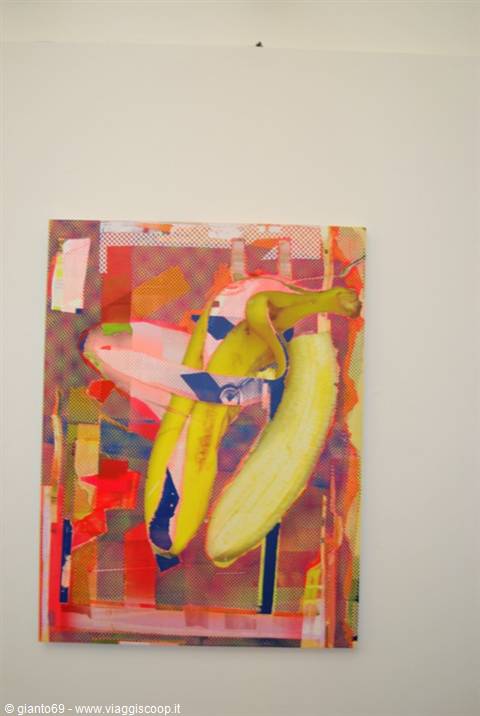 Painting of peeled bananas with colorful collage hanging on white wall