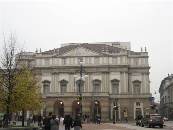 Pedestrians and cars in front of the neoclassical facade of Teatro alla Scala, Milan