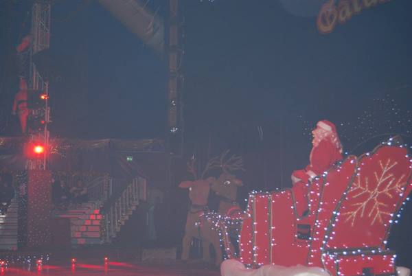 Santa Claus on a red illuminated sleigh with reindeer on stage