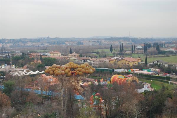 Amusement park with yellow mushroom slides among houses and winter fields