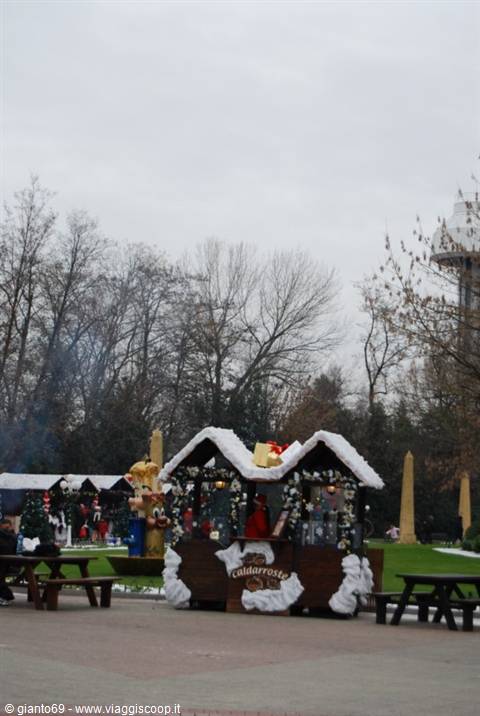 Roasted chestnut stall with fake snow in winter park, wooden tables