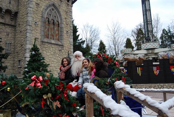 Children with Santa Claus on a decorated sleigh by the stone castle