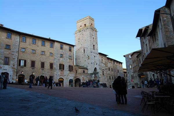 Tourists in San Gimignano's main square beneath the medieval stone tower