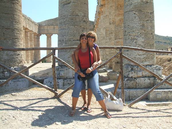 Two tourists hugging in front of the Doric columns at Segesta temple