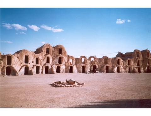 Ksar with earthen arched granaries under a blue sky