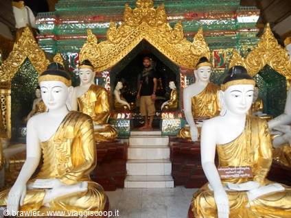Golden and white Buddha statues, tourist standing in the shrine entrance
