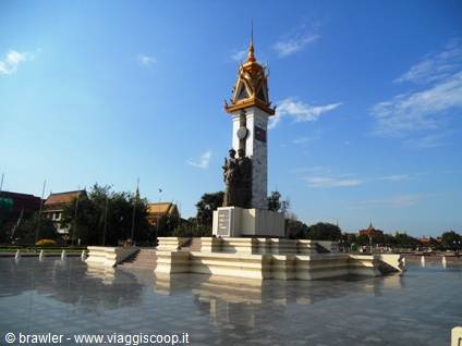 Norodom Sihanouk bronze statue on white pedestal in Phnom Penh, blue sky