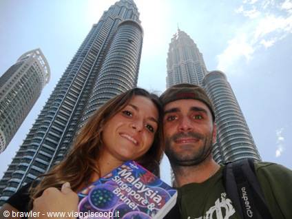 Couple with guidebook in front of the Petronas Towers, Kuala Lumpur