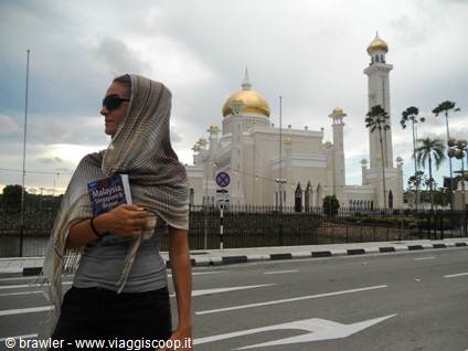 Woman with headscarf and guidebook in front of Omar Ali Saifuddien Mosque