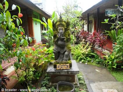 Stone Ganesha statue surrounded by tropical plants in a hotel garden