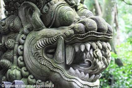 Moss-covered stone guardian statue in Ubud, Bali