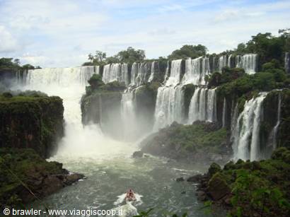 Iguazú Falls, powerful water cascades among lush greenery, boat below the falls