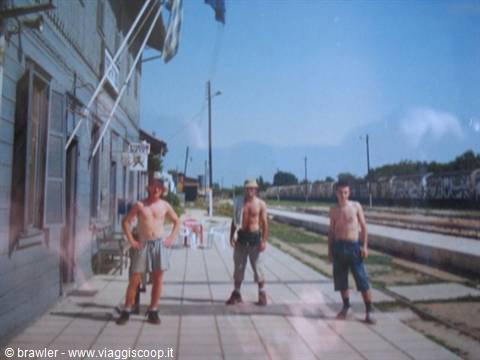 Three shirtless young men on the railway station platform, blue sky