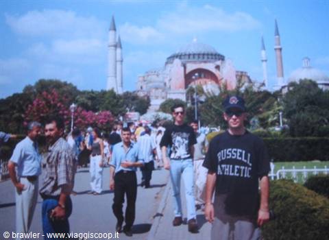 Tourists walk in front of Hagia Sophia, minarets and dome under Istanbul's summer sky