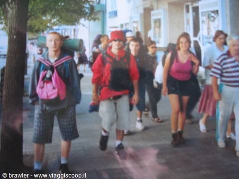 Young backpackers walking with gear on a city sidewalk