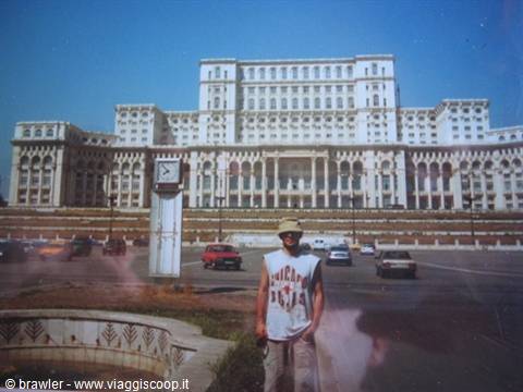 Tourist standing in front of the Palace of Parliament in Bucharest on a sunny day