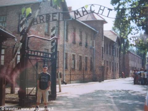 Tourist in front of the Arbeit Macht Frei gate at Auschwitz
