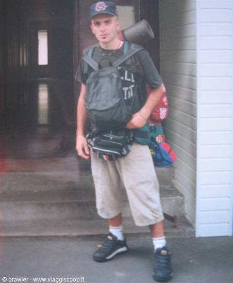 Young man in cap with black backpack, waist pouch, luggage on a step