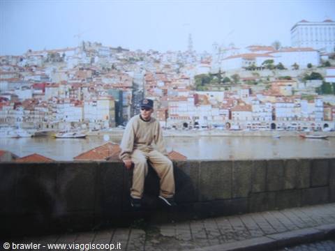 Boy sitting on wall along the Douro river in Porto