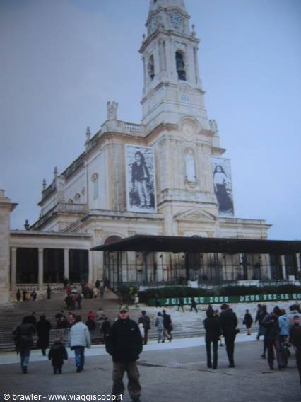 Pilgrims in front of Fatima sanctuary with bell tower and pastor banners