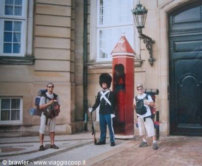 Backpackers posing beside a royal sentry on guard, Amalienborg, Copenhagen
