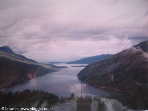 Norwegian fjord surrounded by barren mountains under a cloudy sky