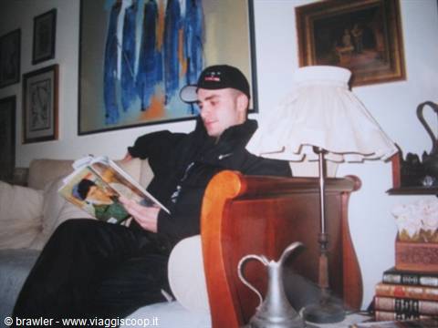 Boy in cap reads a magazine on a wooden armchair
