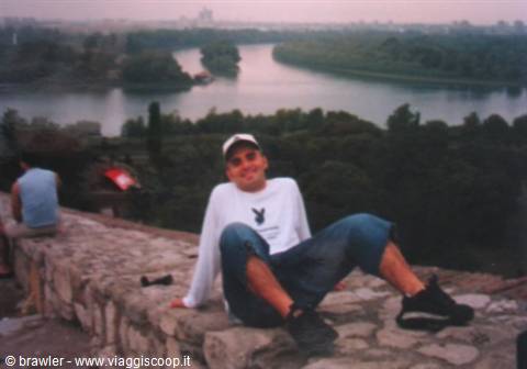 Guy sitting on stone wall at the two rivers confluence, Belgrade