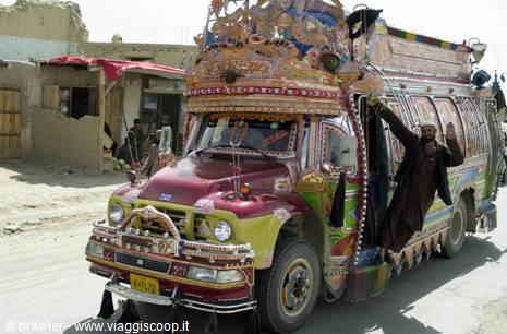Hand-painted jingle truck, man hanging from the door on a dusty rural road