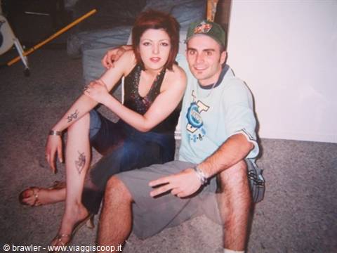 Young couple sitting on a couch, he wears a cap, indoor flash photo
