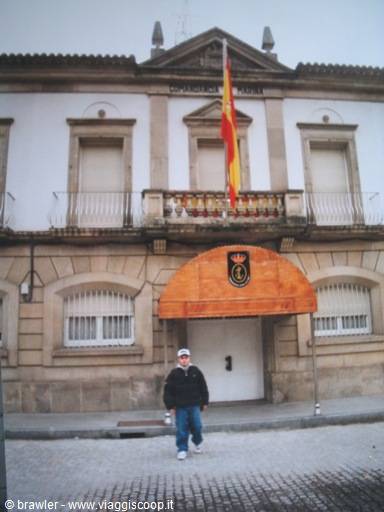 Tourist in front of a police headquarters with Spanish flag, curved wooden entrance