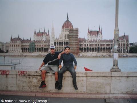 Two friends sitting on the Danube wall in front of Budapest Parliament