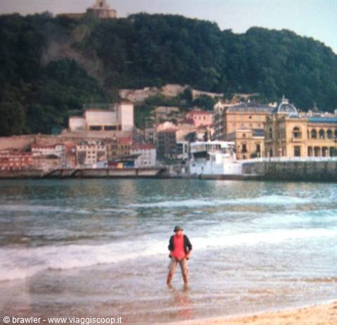 Man in red shirt by the wave at La Concha beach, San Sebastián