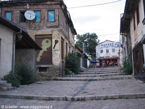 cobbled uphill street lined with old stone and wooden houses, Mateks sign