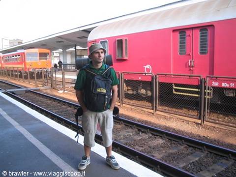 Backpacker standing on platform next to a stationary red train