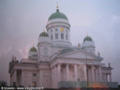 White cathedral with green domes under cloudy sky in Helsinki