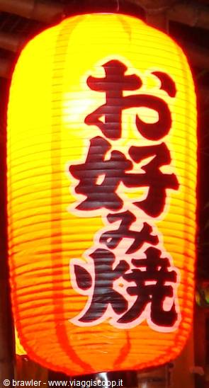Glowing paper lantern with Japanese characters advertising okonomiyaki