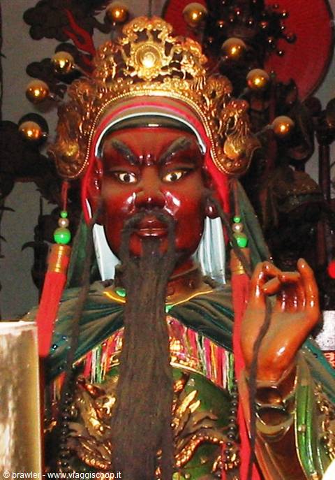 Painted Guan Yu statue with golden crown inside a Chinese temple