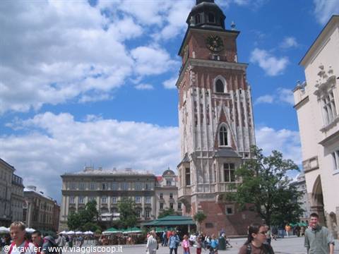 Tourists stroll across the square in front of Kraków's Gothic Town Hall Tower