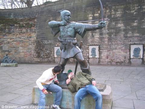 Robin Hood bronze statue in Nottingham, two tourists lounging at its base