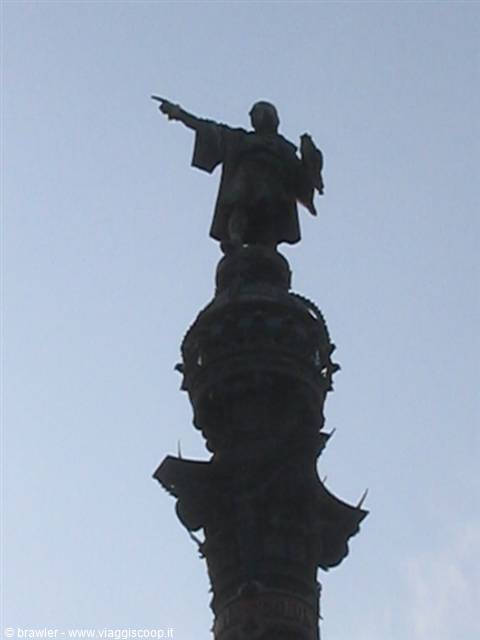 Bronze statue of Colom pointing seaward, silhouetted against the sky