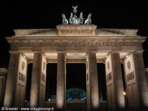 Brandenburg Gate at night, lit columns and bronze quadriga against black sky