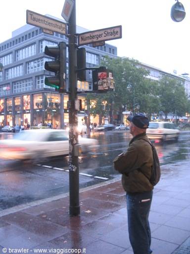 Man with backpack waiting at the traffic light at Kurfürstendamm intersection, Berlin