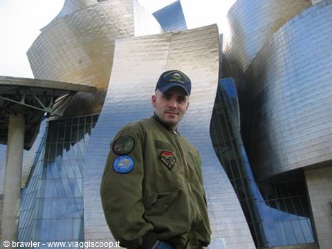 Man in military jacket in front of the titanium curves of the Guggenheim Bilbao