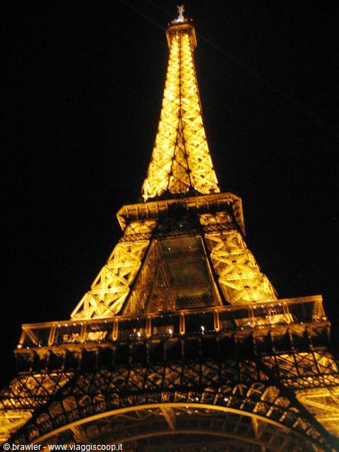 The Eiffel Tower glowing in golden lights against the black Paris night